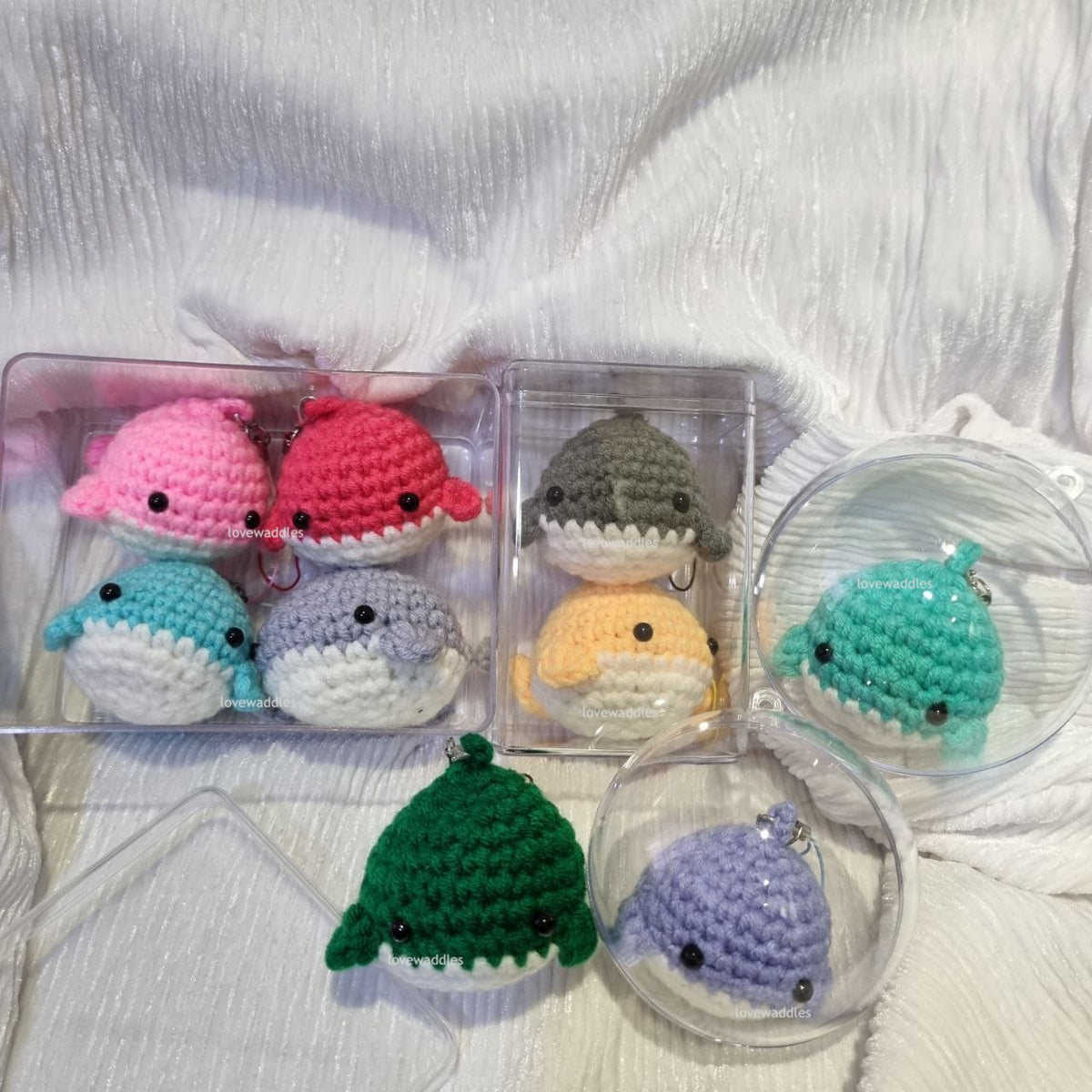 All acrylic display cases with crochet whales in it